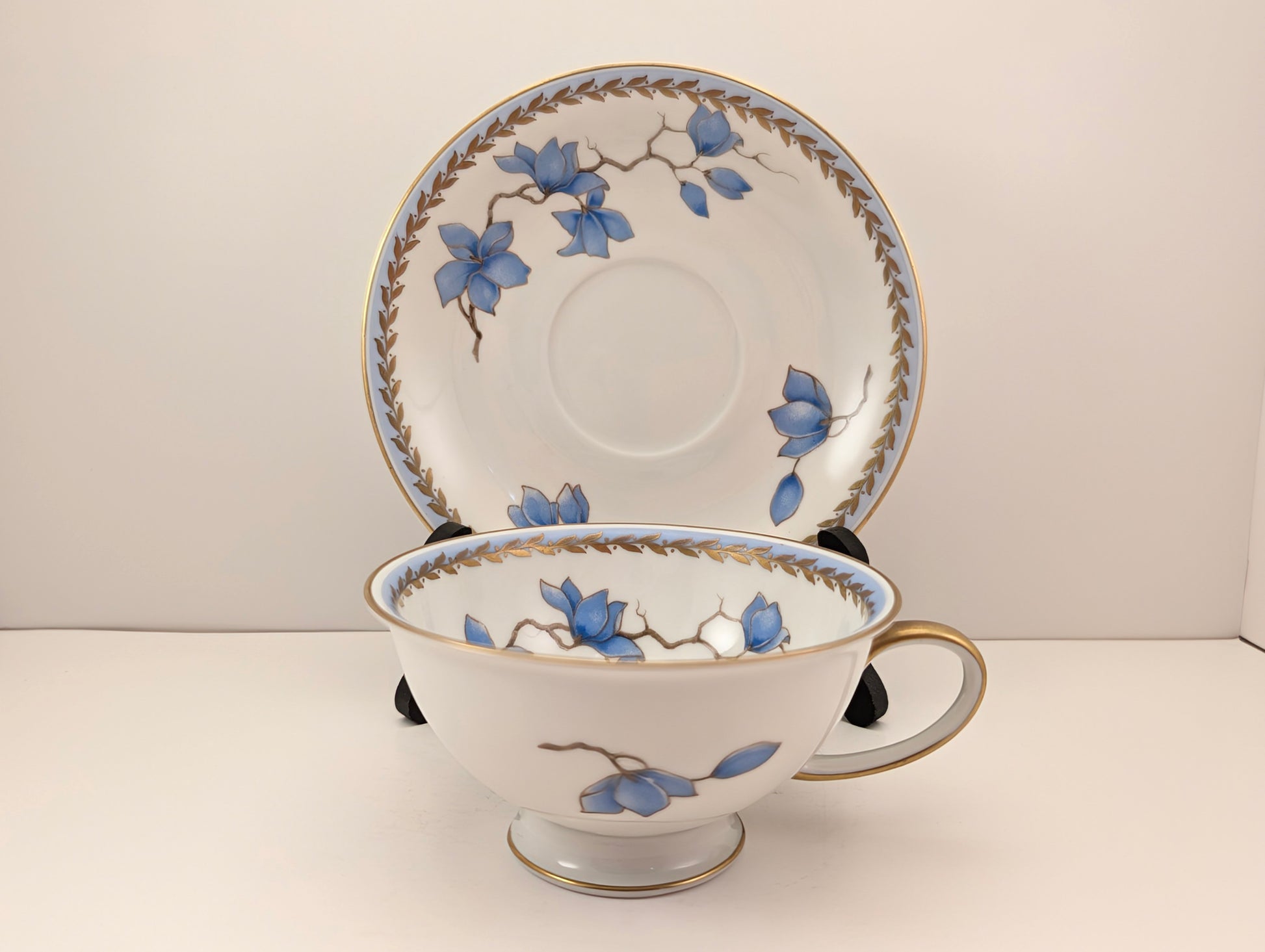 Display View of a 1940s Rosenthal Blue Danube Cup & Saucer Set with the cup framed by the saucer on a plate stand.
